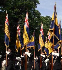people marching with ceremonial flags & flagpoles