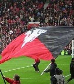 hand waving flagpoles at football match