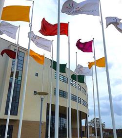 lots of colourful flags flying on flagpoles at holiday park