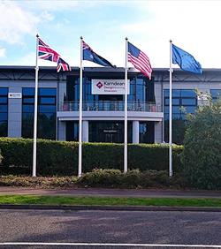 flagpoles with flags flying outside factory