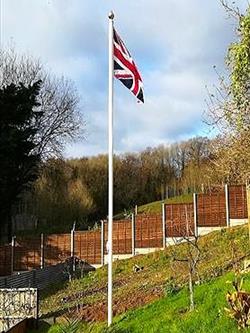 Classic Flagpole with flag flying in a garden