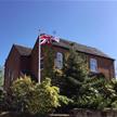 Classic fibreglass flagpole installed in a garden with a Union Jack flag flying