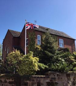 flagpole in a garden flying the Union Jack flag