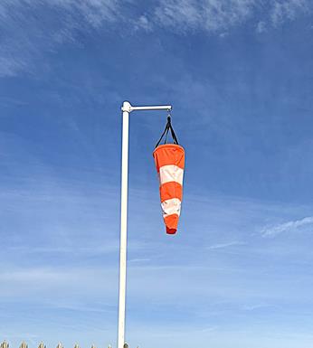 orange and white windsock on a windsock mast
